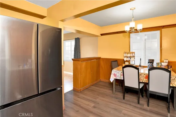 a kitchen with a refrigerator and wooden floor
