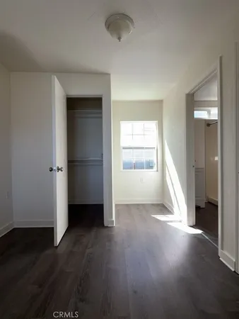 an empty room with wooden floor and a window