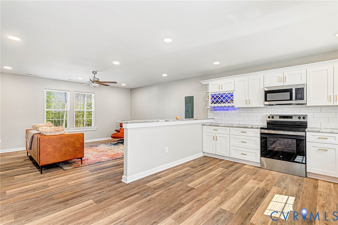 5301 Pine Fork Road Quinton, VA 23141 - Photo 19 of 41 a large white kitchen with stainless steel appliances granite countertop a stove and a wooden floors