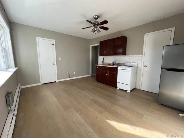 a view of a kitchen with a sink a refrigerator a microwave and a refrigerator