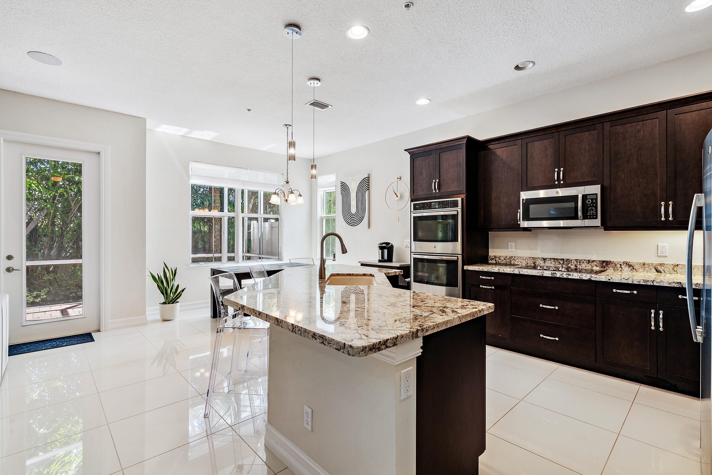 a large kitchen with granite countertop a large counter top appliances and cabinets