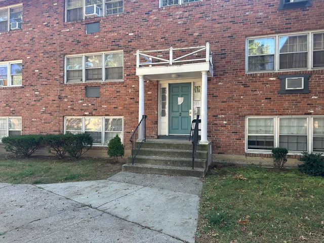 front view of a brick house with a yard