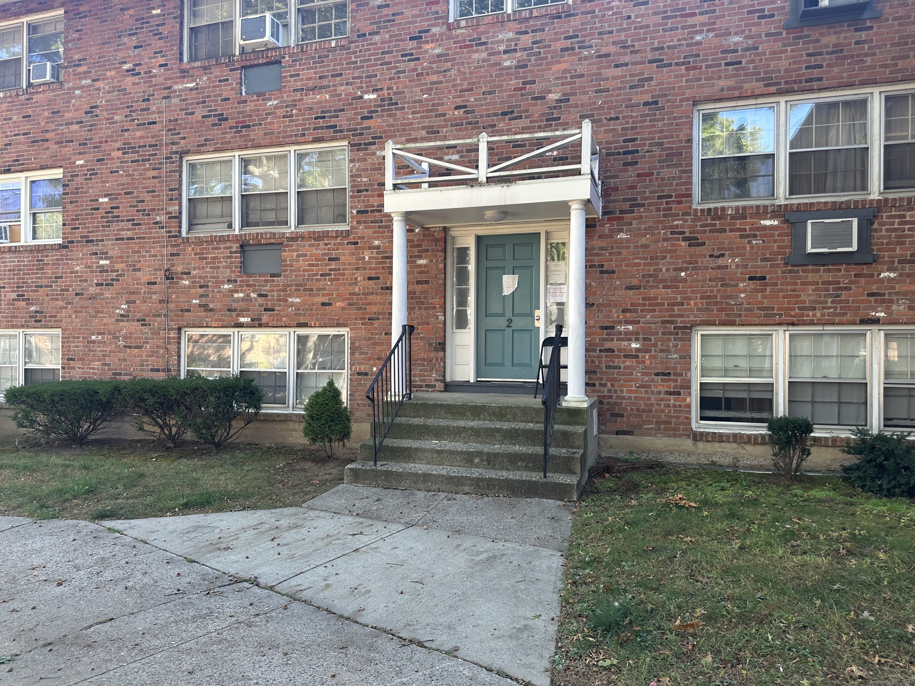 front view of a brick house with a yard
