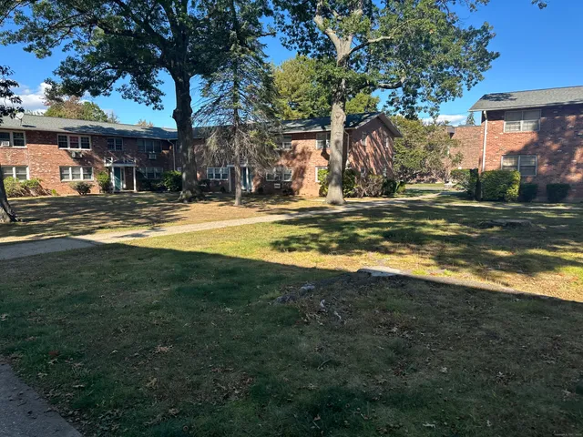 a view of a house with a yard and sitting area