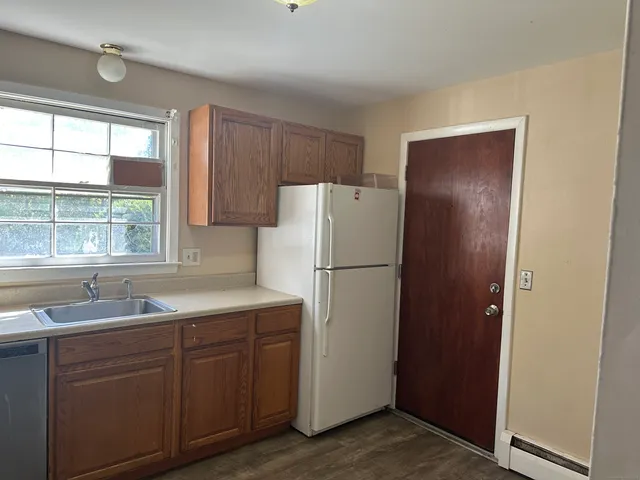 a kitchen with a refrigerator sink and cabinets