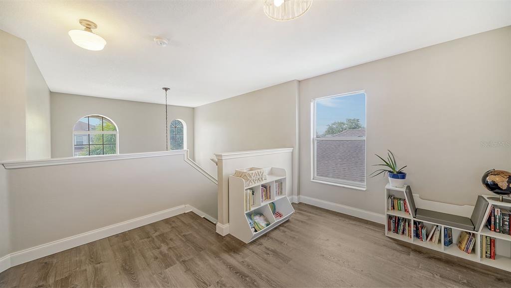 6122 Blue Runner Court Lakewood Ranch, FL 34202 - Photo 18 of 53 a view of an empty room with a window and wooden floor