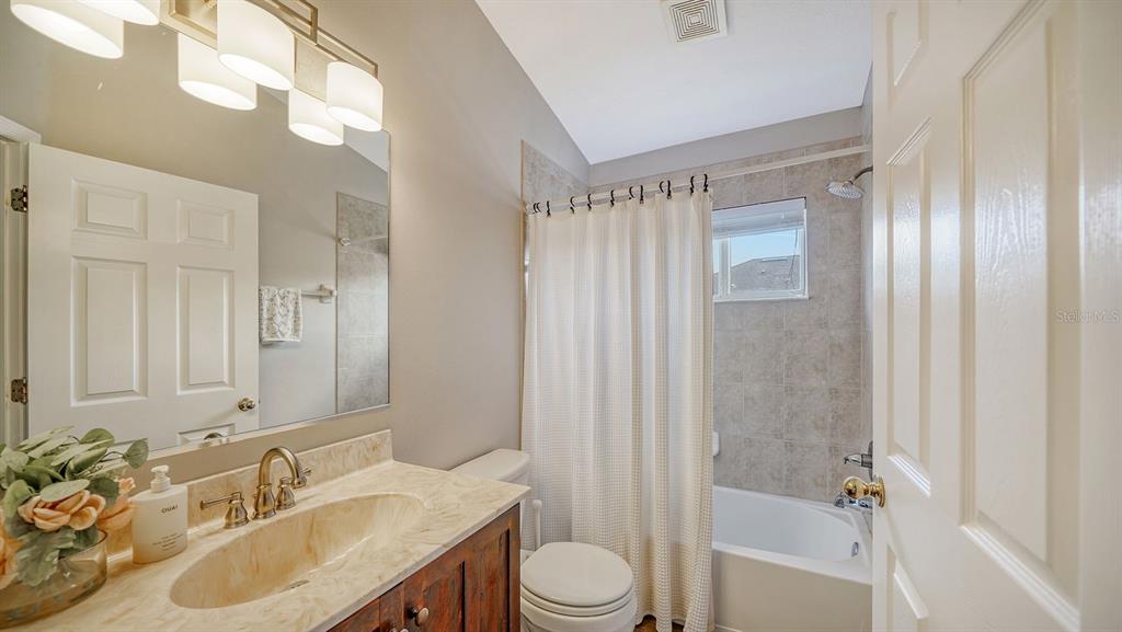 6122 Blue Runner Court Lakewood Ranch, FL 34202 - Photo 26 of 53 a bathroom with a granite countertop sink toilet and shower