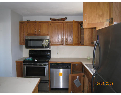27 Broadcommon Road Bristol, RI 02809 - Photo 3 of 9 a kitchen with stainless steel appliances a stove a microwave and a refrigerator