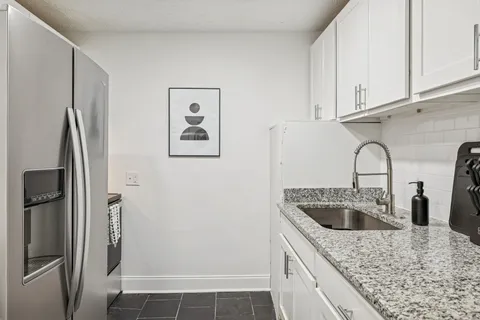 a kitchen with stainless steel appliances granite countertop a sink stove and refrigerator