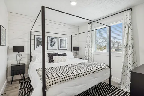 a bedroom with a bed and a large mirror