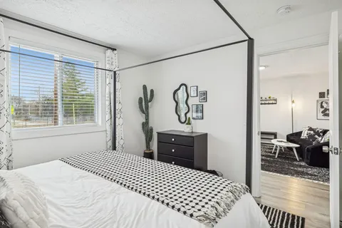 a bedroom with a bed and wooden floor