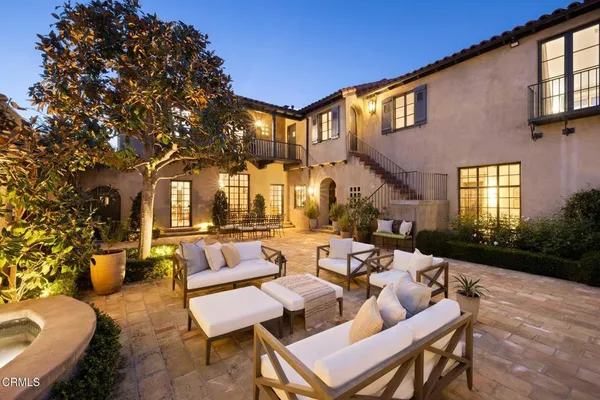 a view of a patio with couches table and chairs and potted plants