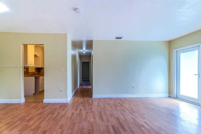 a view of empty room with wooden floor