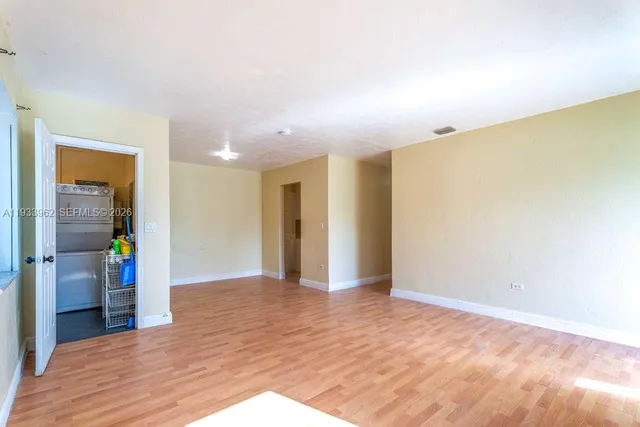 a view of an empty room with wooden floor