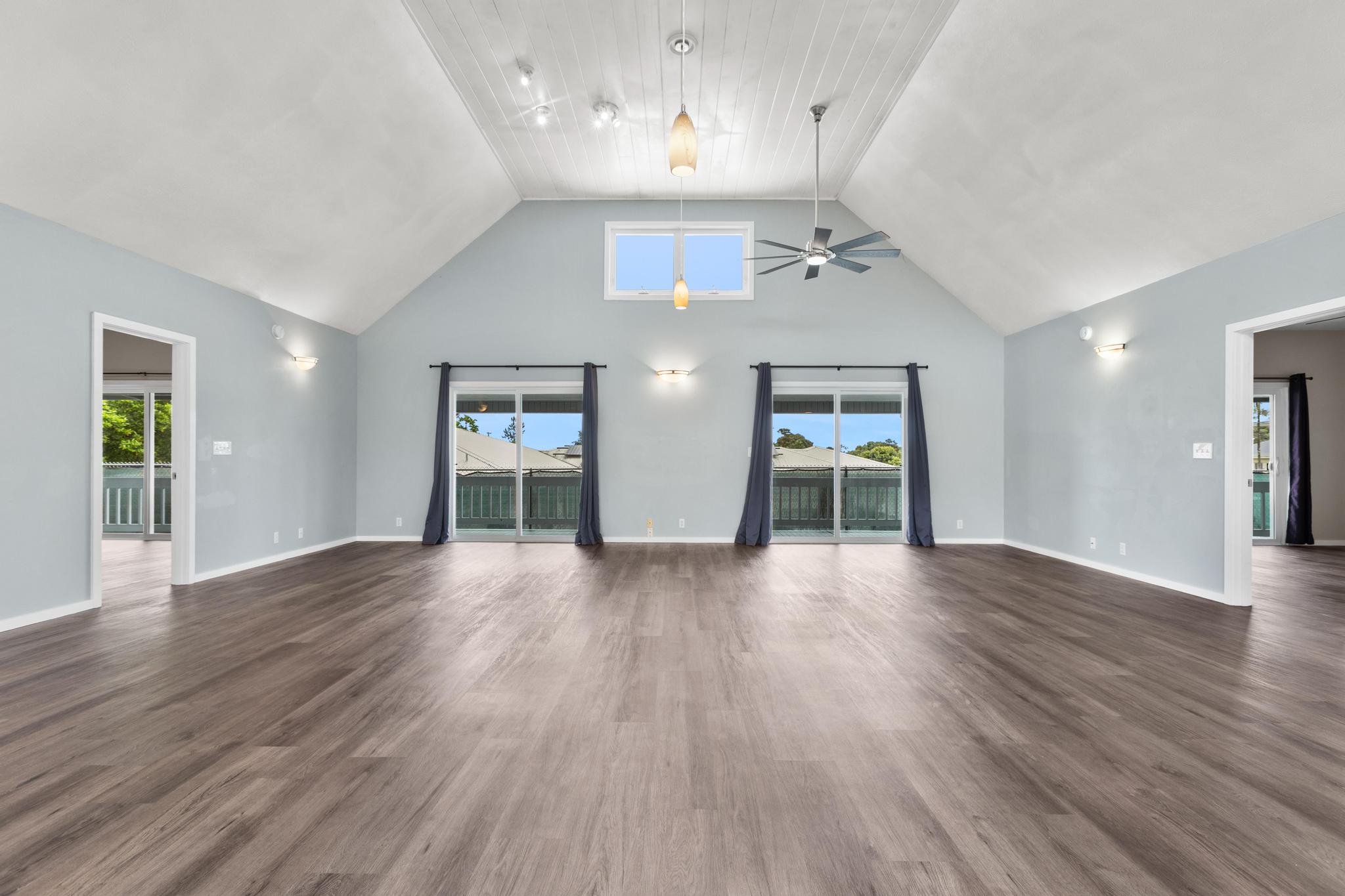 234 Kipa Street Hilo, HI 96720 - Photo 19 of 30 an empty room with wooden floor chandelier entryway and windows