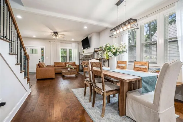 a dining room with furniture a chandelier and wooden floor