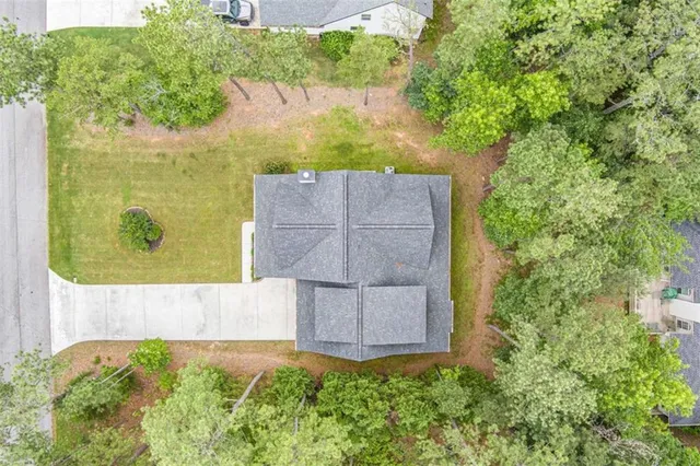 an aerial view of residential house with outdoor space and trees all around