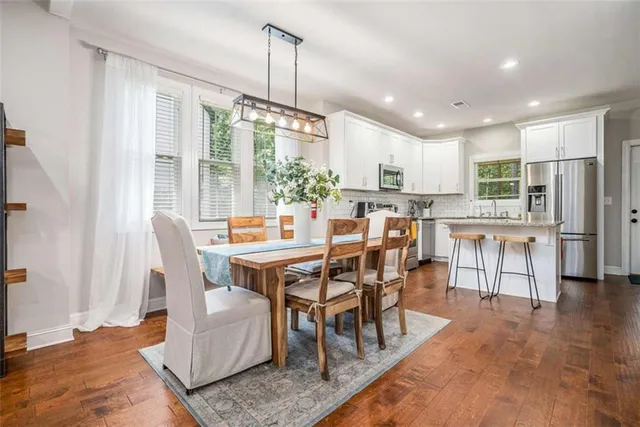 a view of a dining room and livingroom with furniture wooden floor a chandelier