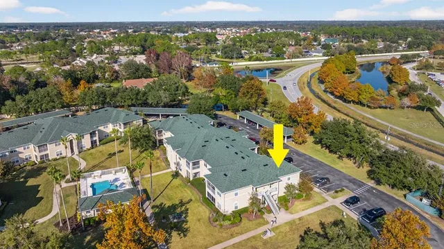 a view of a house with brick walls plants and large tree