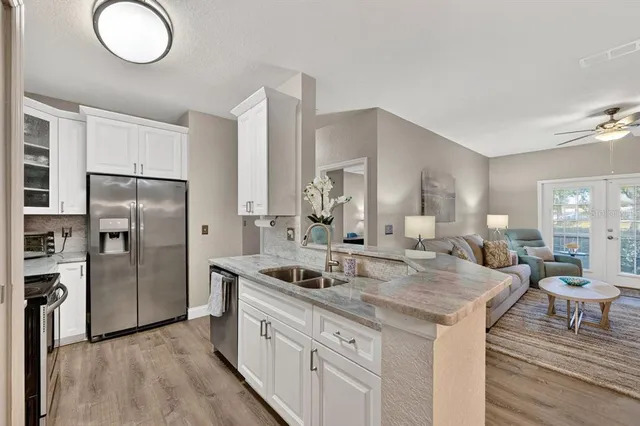 a kitchen with stainless steel appliances granite countertop a sink and a refrigerator