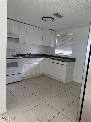 a kitchen with granite countertop white cabinets and white appliances