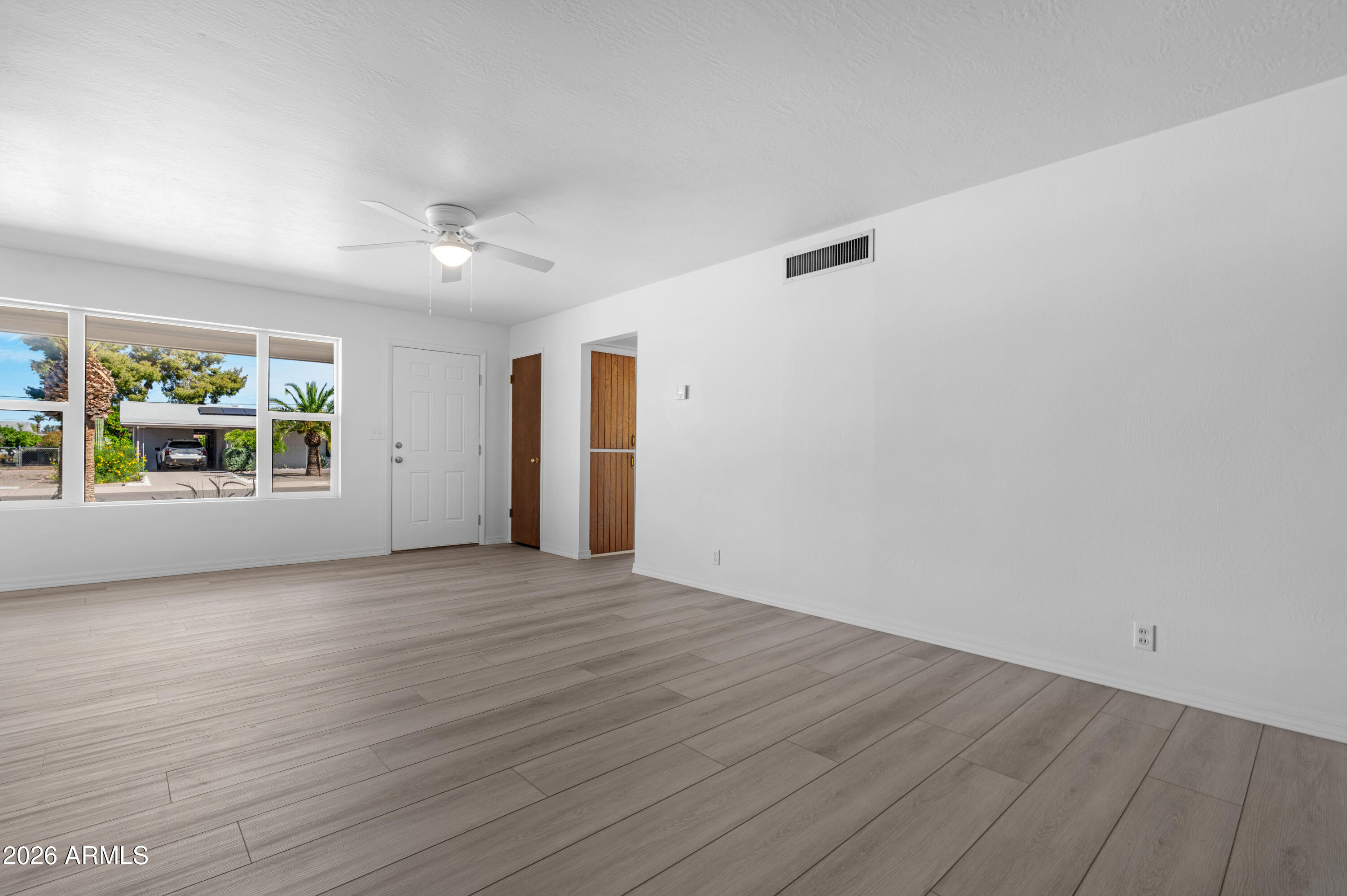 5437 East Butte Street Mesa, AZ 85205 - Photo 11 of 56 an empty room with wooden floor and windows