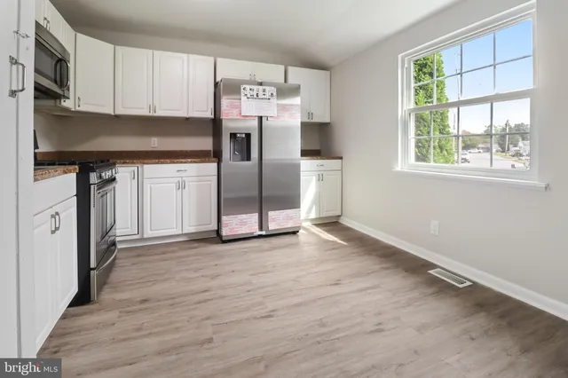 a kitchen with stainless steel appliances a refrigerator sink and microwave