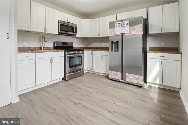 a kitchen with white cabinets and stainless steel appliances