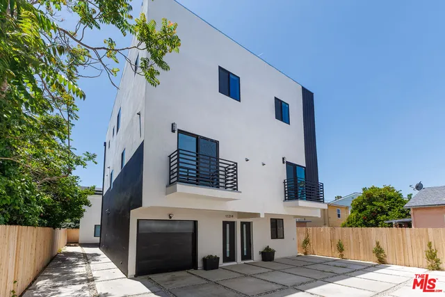 a front view of a house with a tree