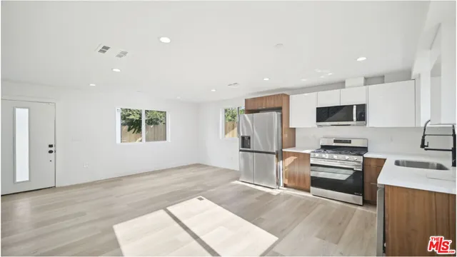 a kitchen with stainless steel appliances granite countertop a refrigerator and a stove top oven