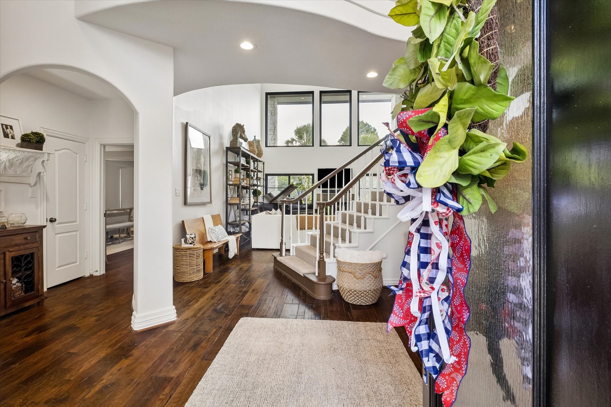 6819 Still Meadow Street Spring, TX 77389 - Photo 4 of 50 Step into a warm and inviting foyer with rich hardwood floors and an elegant staircase leading to the upper level. High ceilings and large windows fill the space with natural light, creating a welcoming atmosphere.