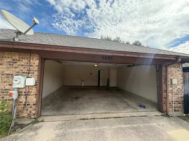 en empty room with wooden floor and fan
