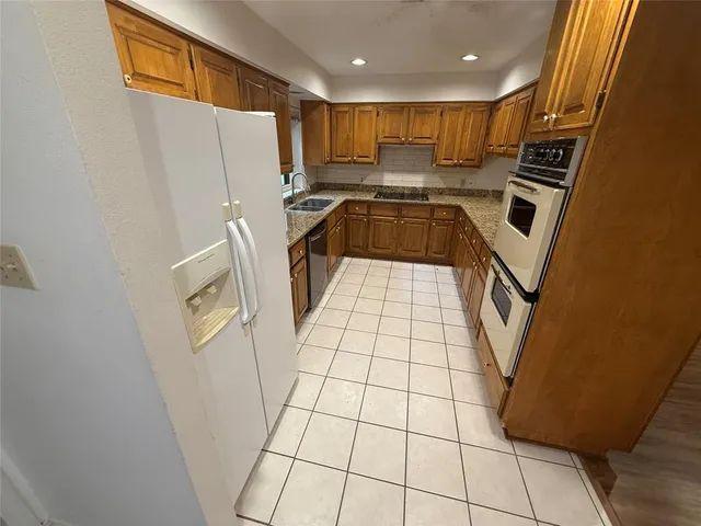 a kitchen with a sink a stove cabinets and a window