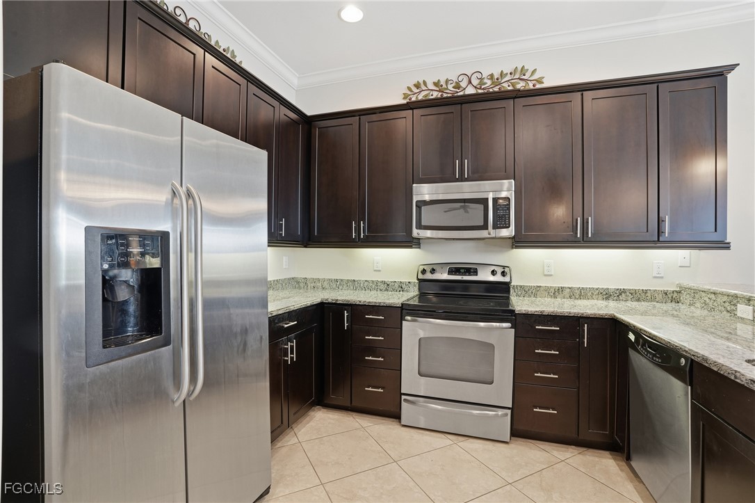 20604 Chestnut Ridge Drive North Fort Myers, FL 33917 - Photo 11 of 49 a kitchen with granite countertop wooden cabinets and stainless steel appliances