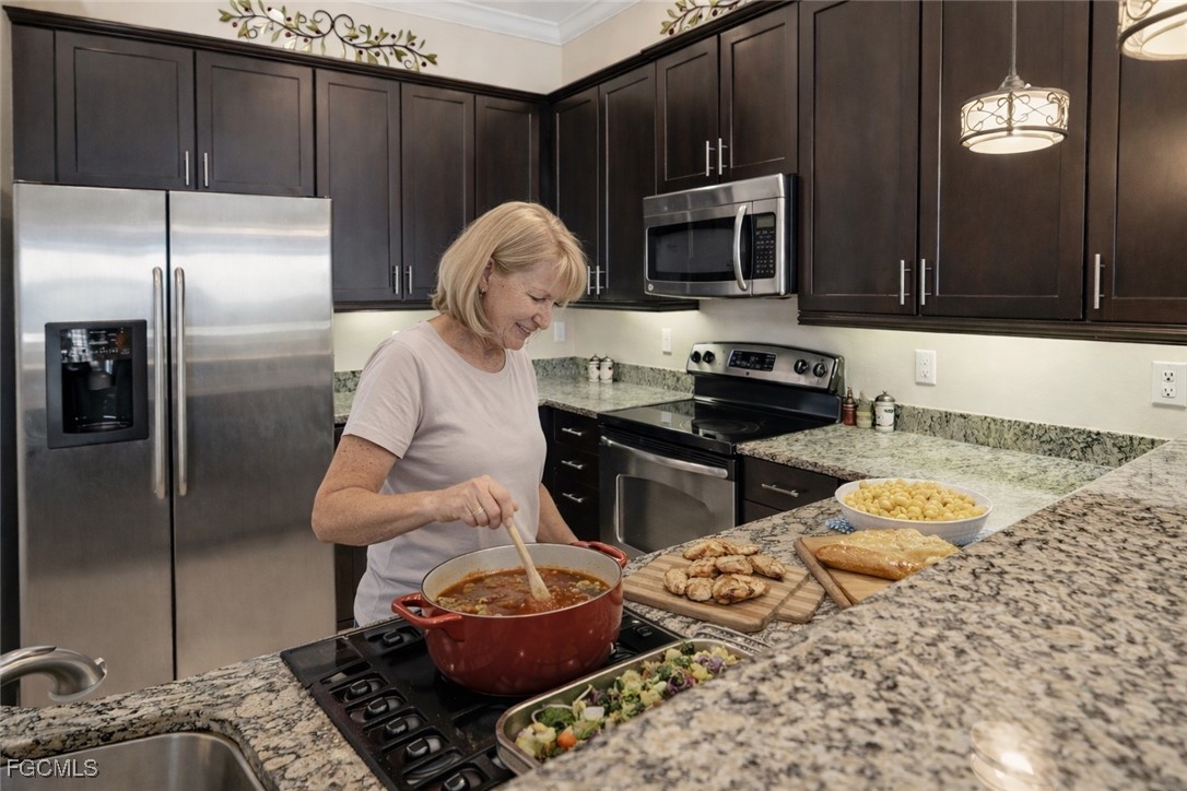 20604 Chestnut Ridge Drive North Fort Myers, FL 33917 - Photo 12 of 49 a kitchen with stainless steel appliances granite countertop a stove a sink and a microwave