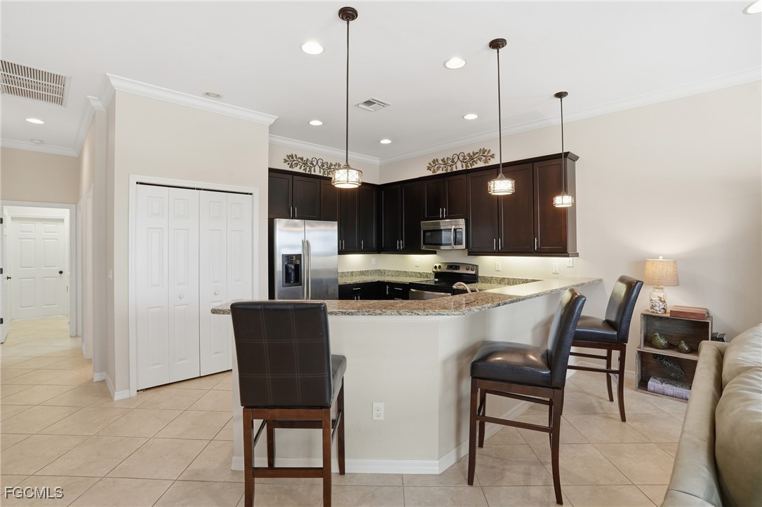 20604 Chestnut Ridge Drive North Fort Myers, FL 33917 - Photo 13 of 49 a kitchen with a refrigerator a dining table and chairs