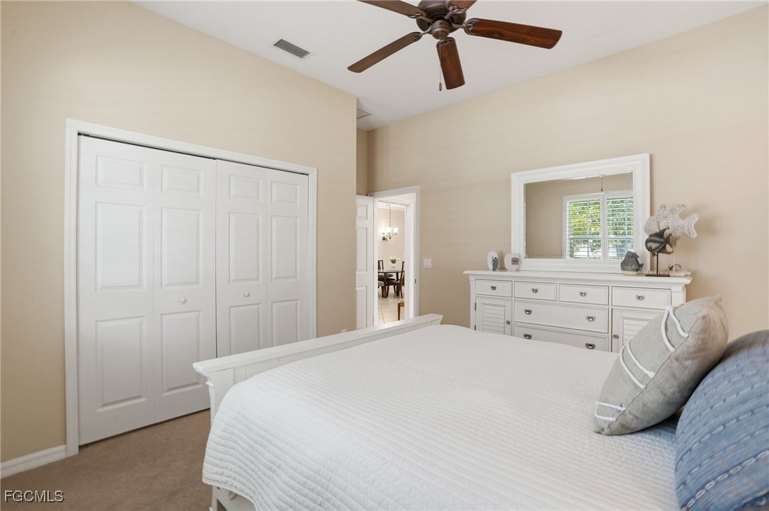 20604 Chestnut Ridge Drive North Fort Myers, FL 33917 - Photo 27 of 49 a bedroom with a bed and a chandelier