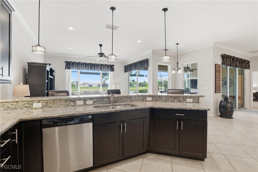 20604 Chestnut Ridge Drive North Fort Myers, FL 33917 - Photo 10 of 49 a kitchen with kitchen island granite countertop a sink a counter space appliances and cabinets