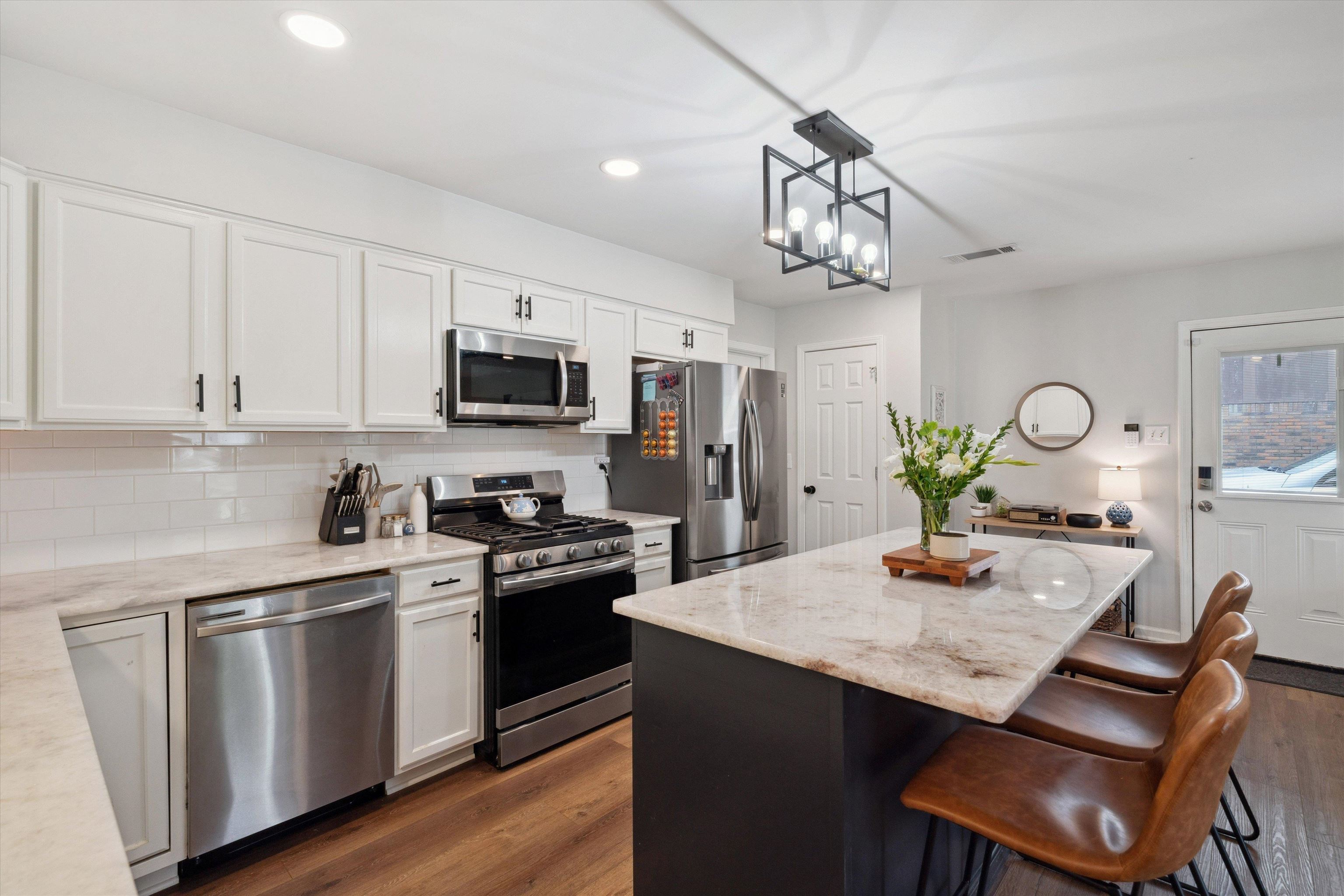 940 Greencliff Road Collierville, TN 38017 - Photo 8 of 23 a kitchen with white cabinets stainless steel appliances and dining table