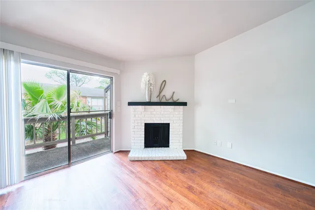 wooden floor fireplace and windows in an empty room