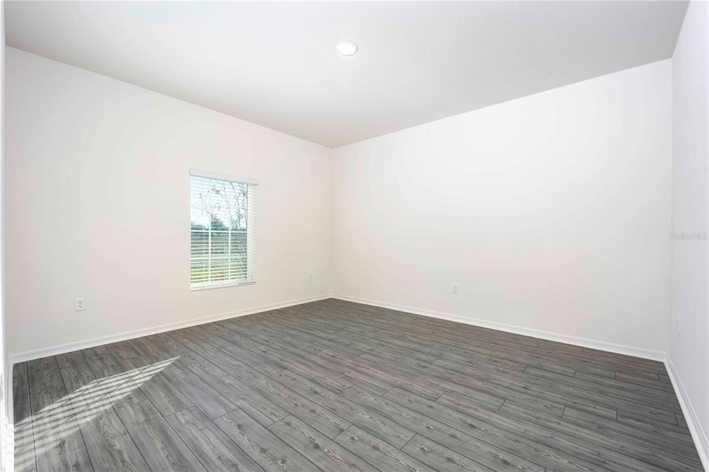 13486 Leaping Water Way Astatula, FL 34705 - Photo 6 of 20 an empty room with wooden floor and windows