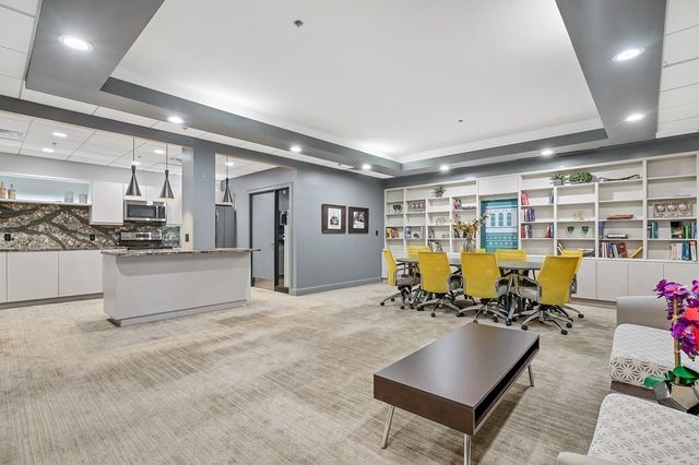 a living room with gym equipment and kitchen view