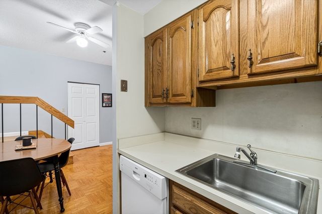 a kitchen with stainless steel appliances a sink dishwasher and cabinets with wooden floor