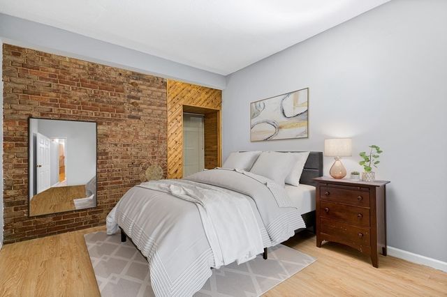 a bedroom with a bed and a large mirror on dresser
