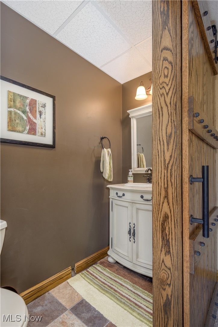 9715 Williams Road Diamond, OH 44412 - Photo 41 of 48 Bathroom with tile patterned floors, toilet, vanity, and a paneled ceiling