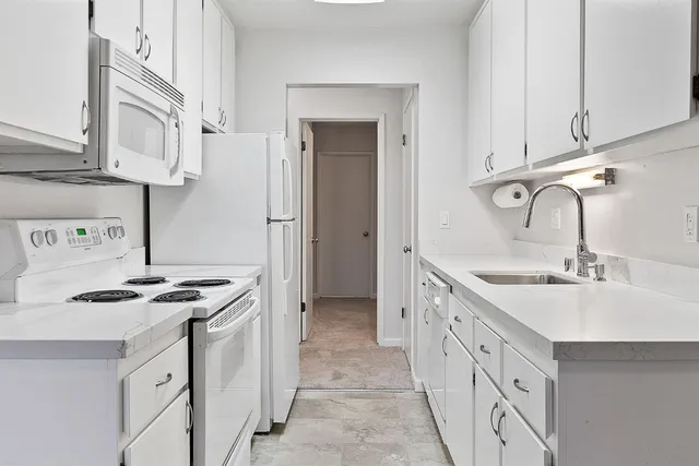 a kitchen with a refrigerator sink and cabinets