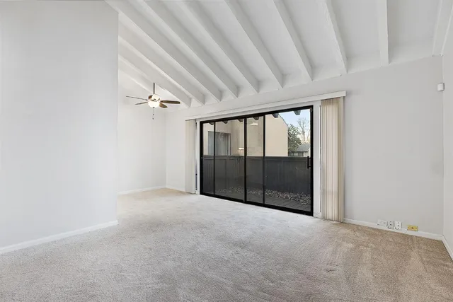 a view of empty room with fireplace and fan