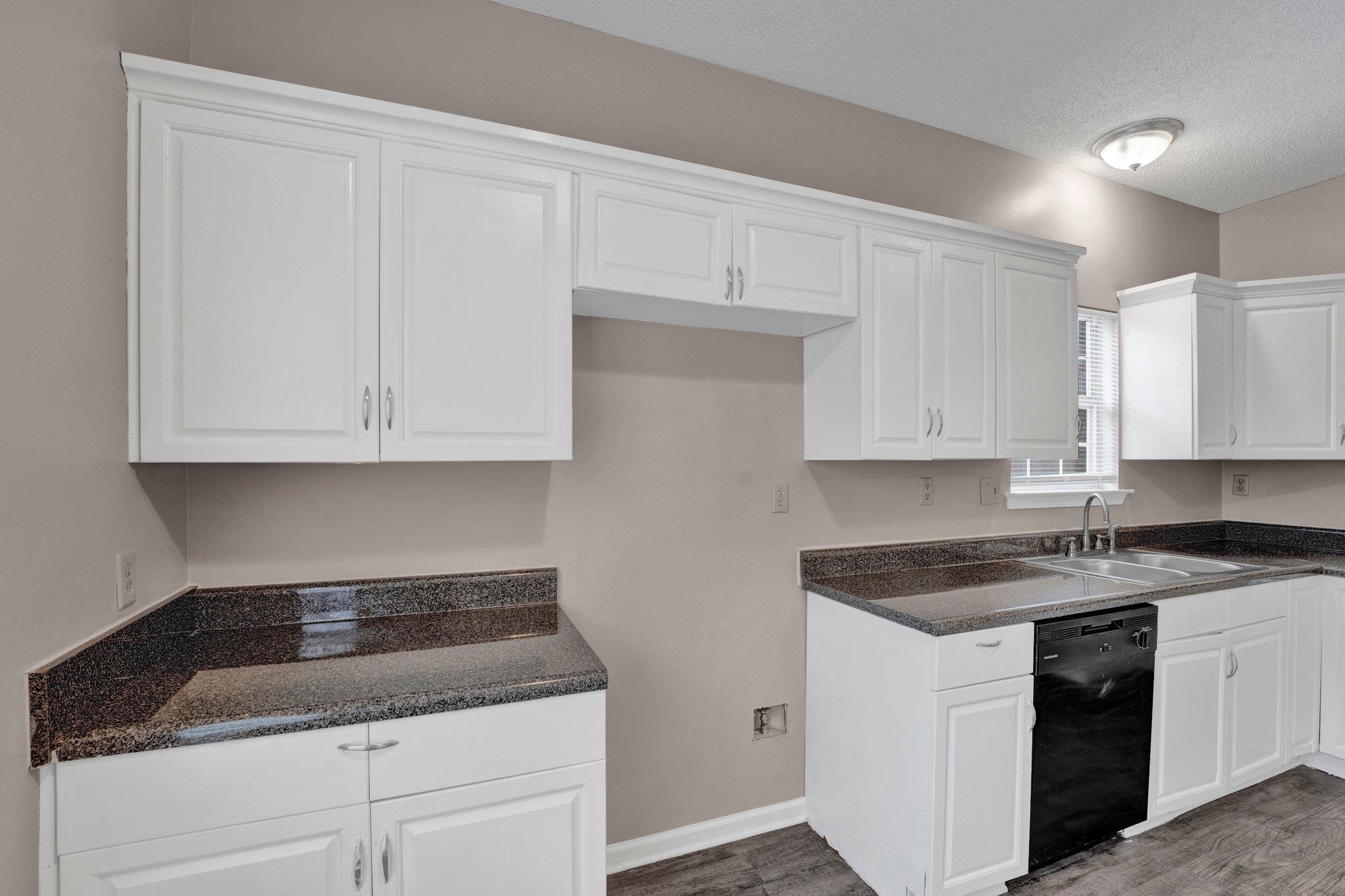 6309 Ragan Farm Drive Memphis, TN 38141 - Photo 13 of 25 Kitchen featuring black dishwasher, dark wood-type flooring, white cabinets, and sink