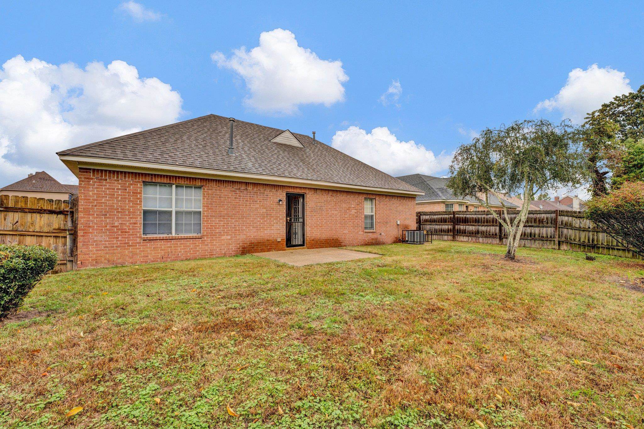 6309 Ragan Farm Drive Memphis, TN 38141 - Photo 22 of 25 Back of property with a patio, cooling unit, and a yard