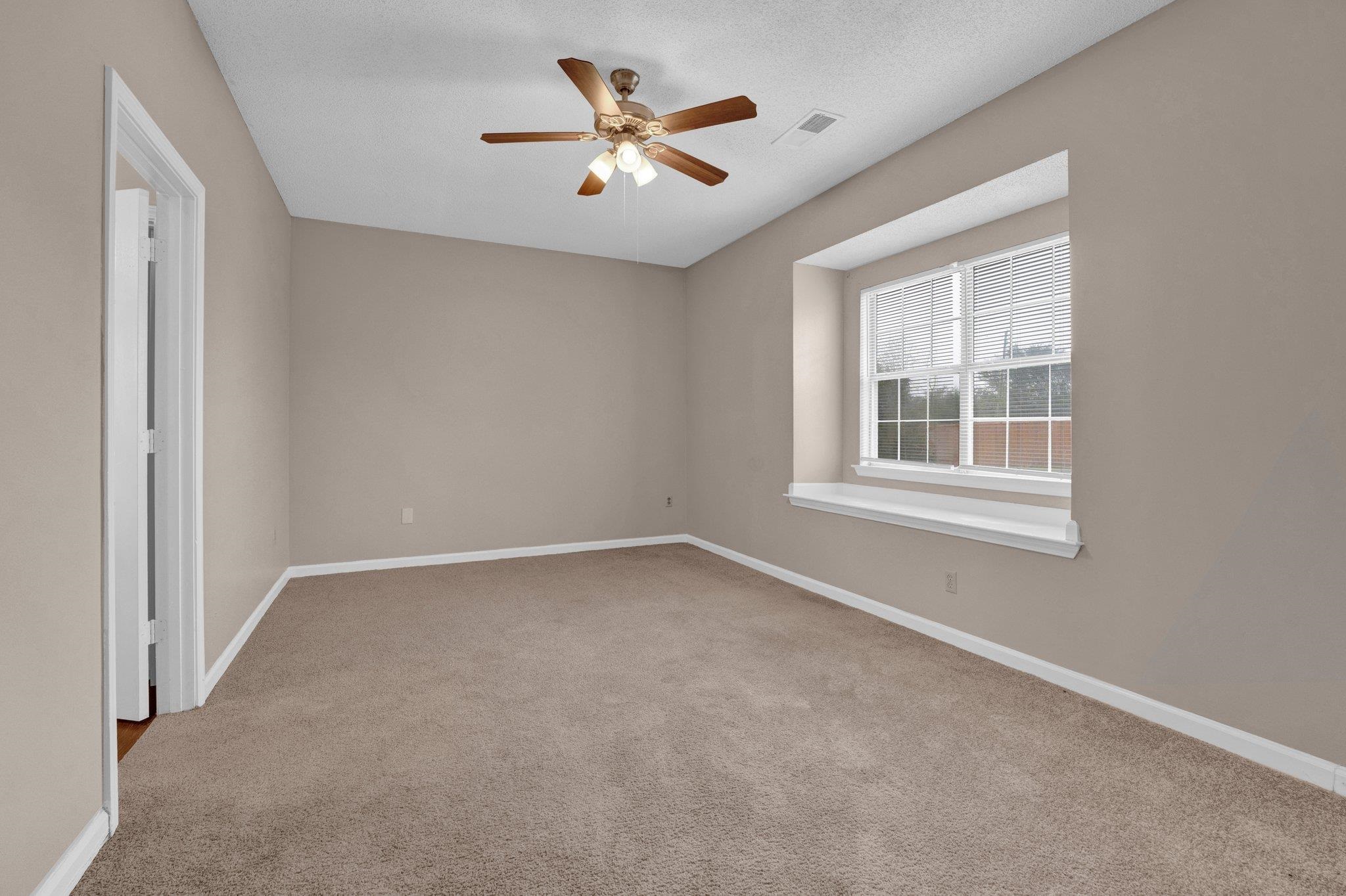6309 Ragan Farm Drive Memphis, TN 38141 - Photo 4 of 25 Empty room featuring a textured ceiling, light colored carpet, and ceiling fan